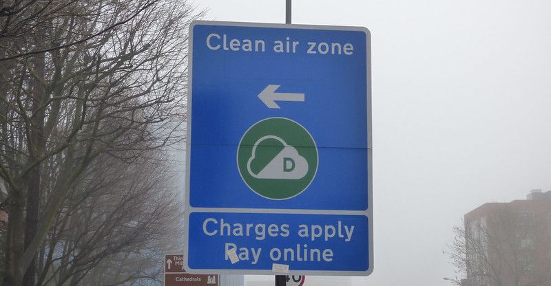 A blue "Clean air zone" street sign on a London street.